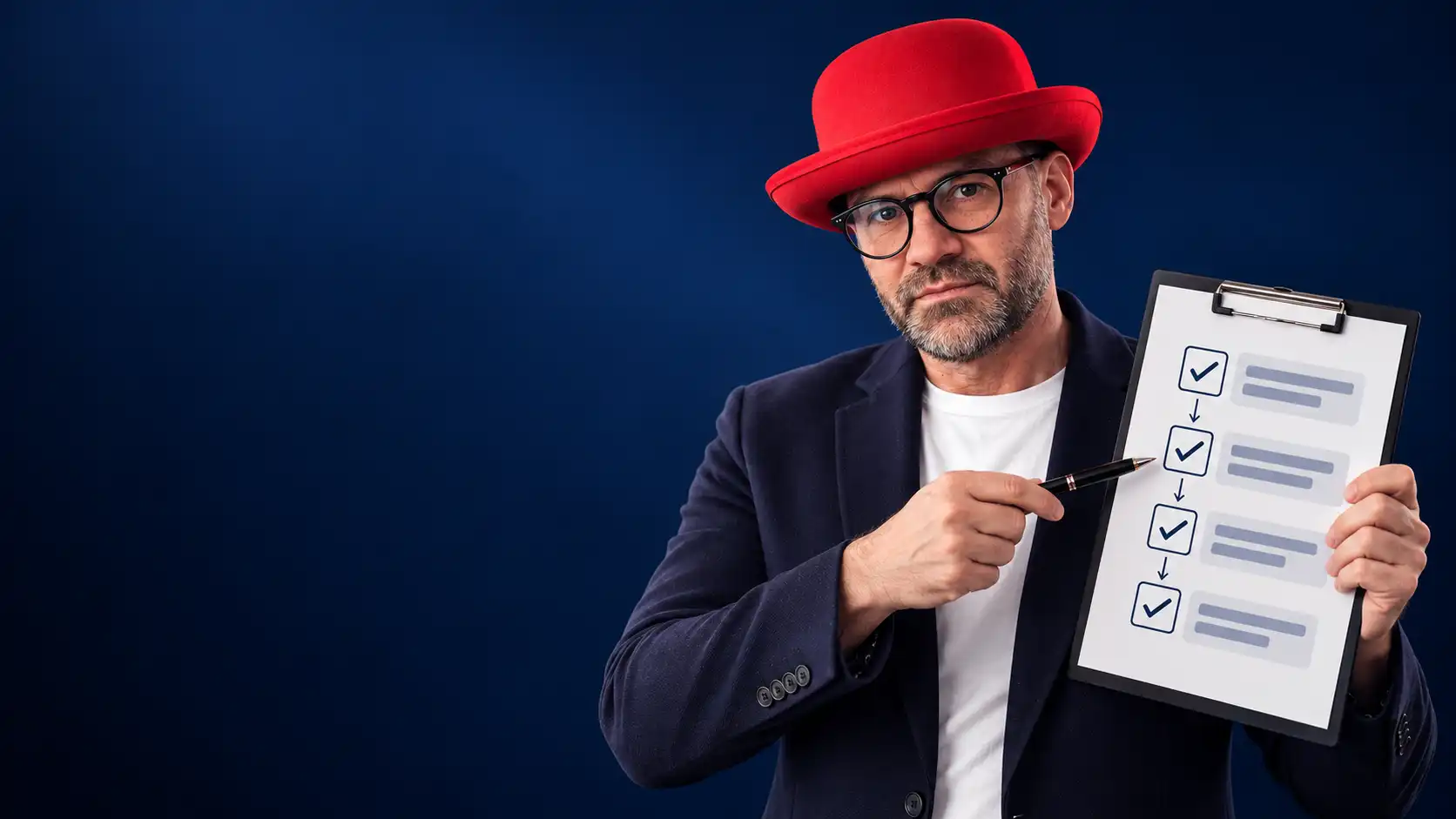 Rafał Kocik wearing a red bowler hat and holding a board showing the stages of a work process